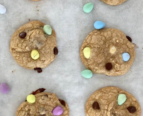 Chocolate chip and Easter egg cookies on a baking tray with candy coated chocolate eggs - Pure Maple