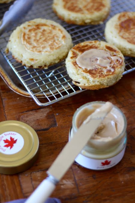 freshly cooked crumpets, jar of maple butter spread over top of crumpet