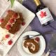 Maple Espresso Roll with Raspberries showing a slice cut and maple syrup bottle - Pure Maple
