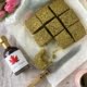 Salted Matcha Brownies with a bite taken from one and maple syrup bottle to the left - Pure Maple