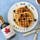 Waffles served with maple syrup and blueberries and pure maple syrup bottle