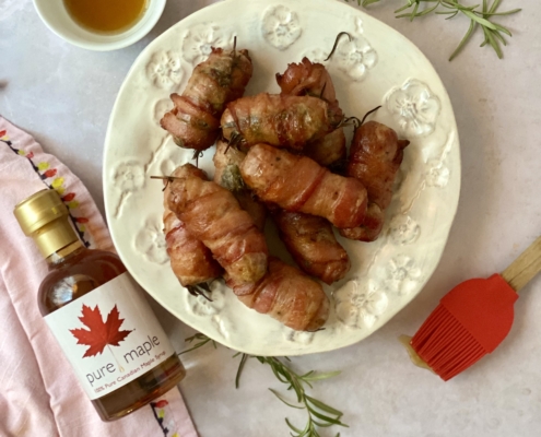 Pigs in blankets with maple glaze and maple bottle